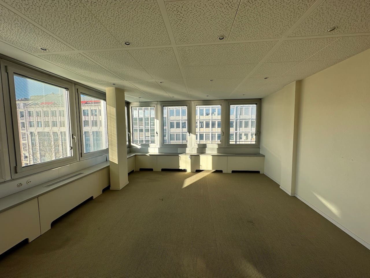 État existant avant travaux — plateau vide avec moquette beige et cloisonnement inadapté, Bd Helvétique Genève