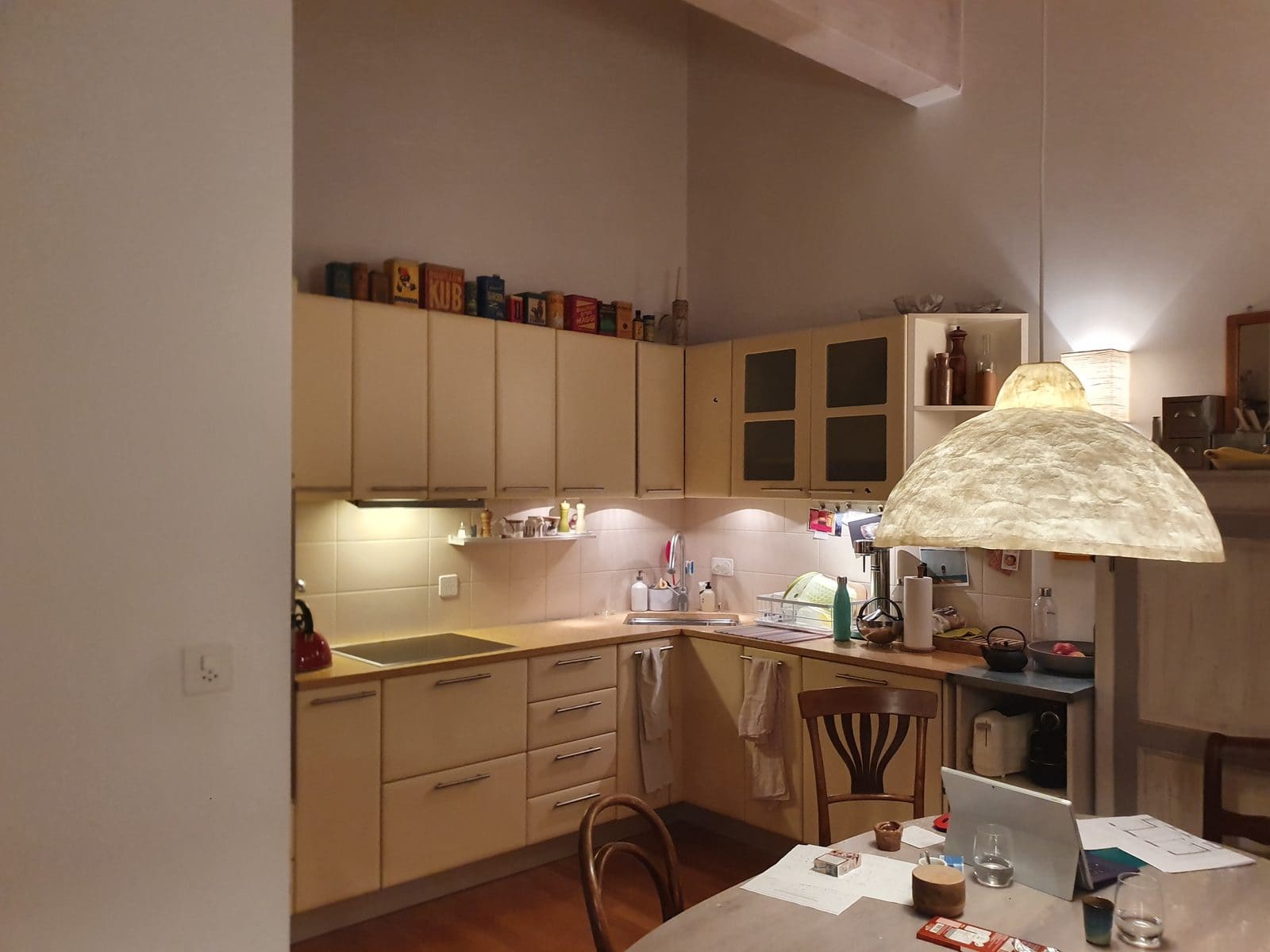 Cuisine existante avant travaux — configuration en L beige datée, appartement rive gauche Genève