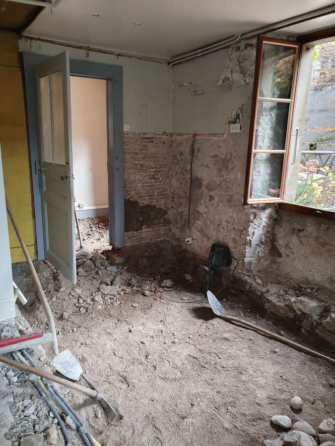 Rez-de-chaussée chantier — sol cassé, murs briques et pierre