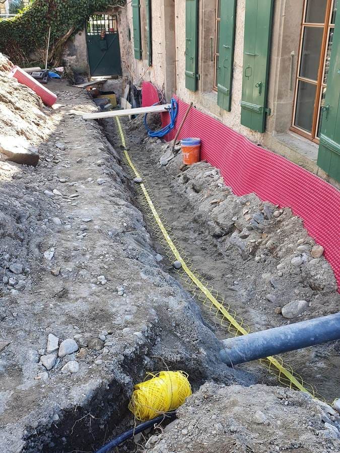 Tranchée drainage périphérique maison de village — voile de protection rose