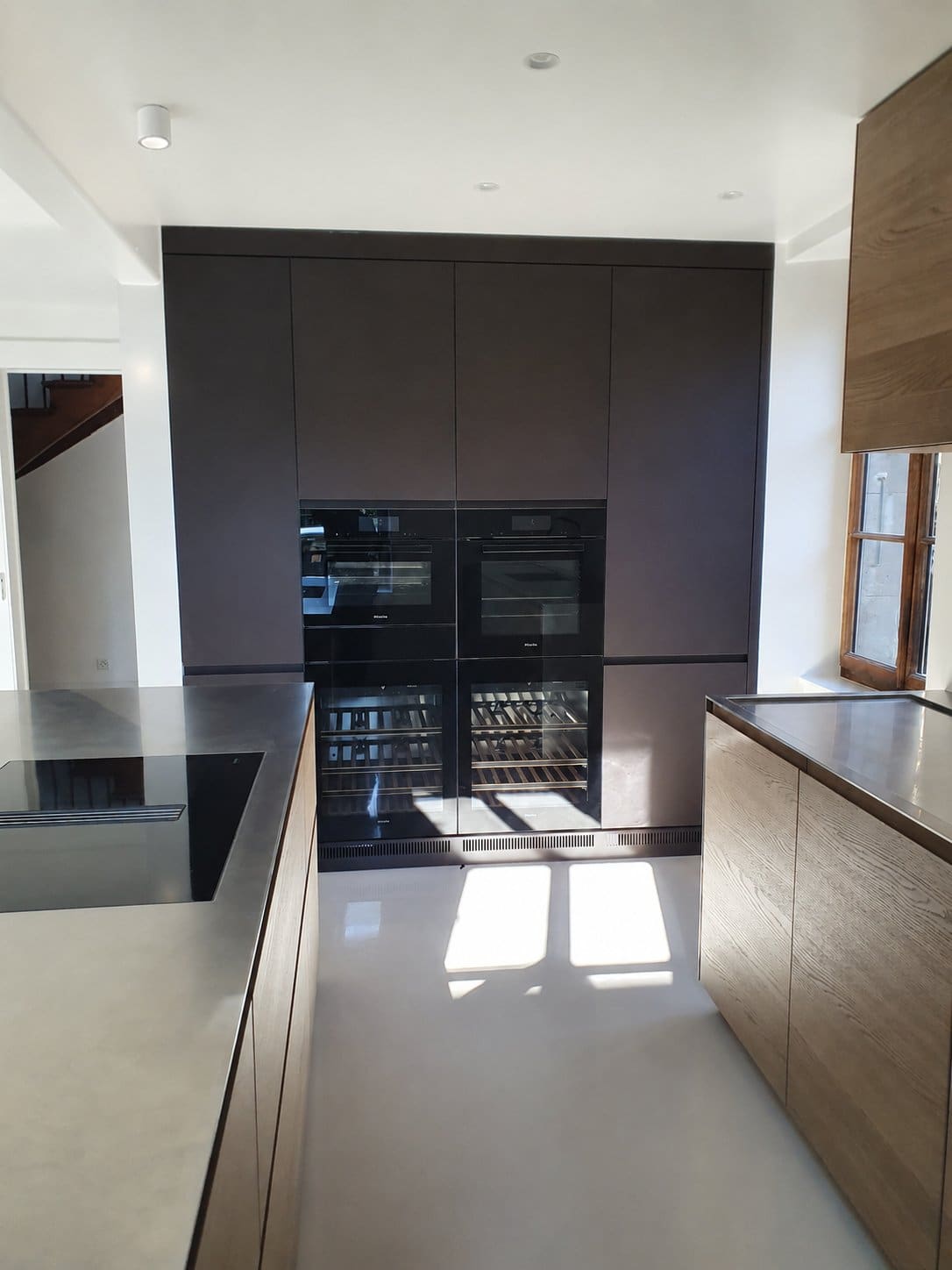 Cuisine ouverte maison de village — plan inox, four et combiné Miele