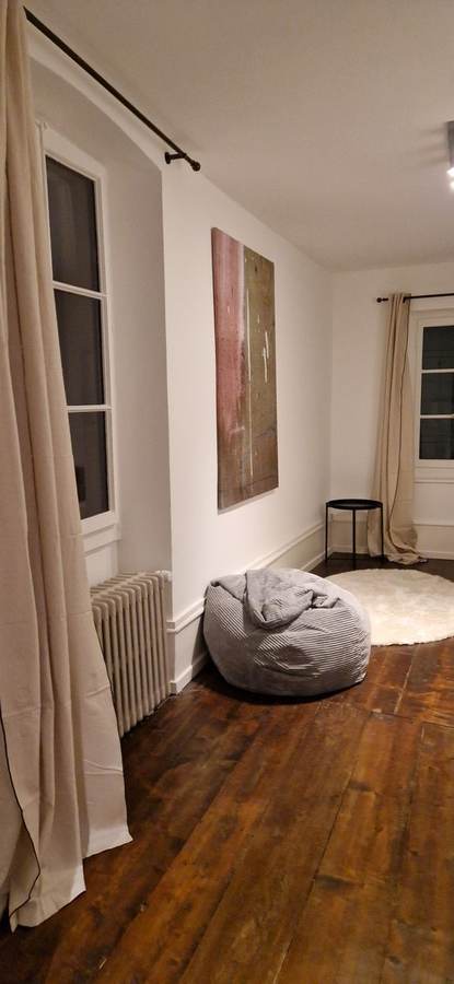 Chambre maison de village — planchers décloués reteinté, tableau abstrait, tapis